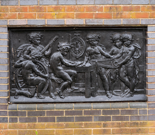 An embossed metal artwork of cherubs building a bicycle