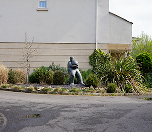 A statue of a man holding a heavy ball