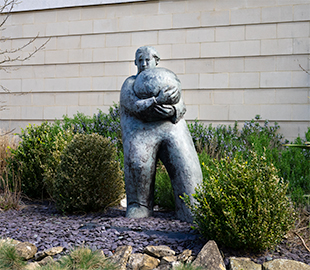 A statue of a man holding a heavy ball