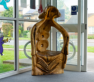 A carved wooden chair depicting an old woman