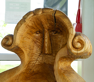 A carved wooden chair depicting an old woman