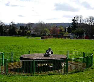 A weathered statue of a lying man in Cheltenham