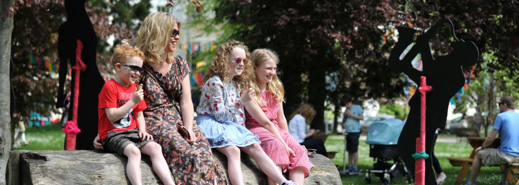 Family sitting in Montpellier Gardens during the Cheltenham Jazz Festival